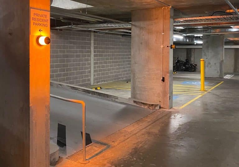 A vehicle detection system installed in a private resident parking garage, featuring an illuminated traffic light and clear signage for vehicle access control.
