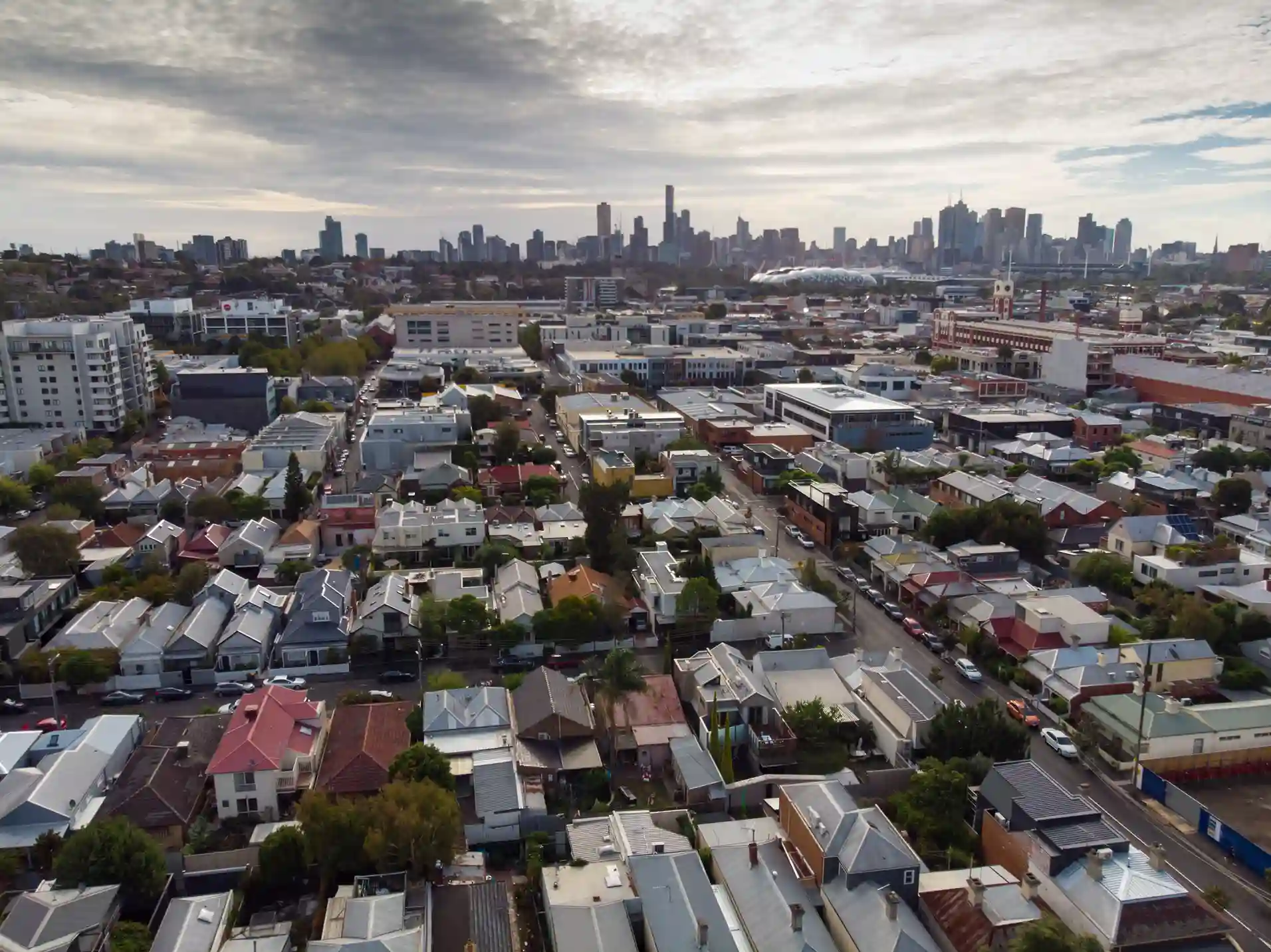 Aerial view of a densely packed urban area in Richmond with residential and commercial buildings, showcasing the city skyline in the background