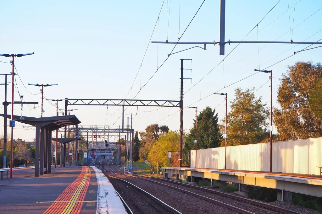 Electrical infrastructure at Bentleigh East train station showcasing commercial electrical systems with overhead power lines and lighting installations