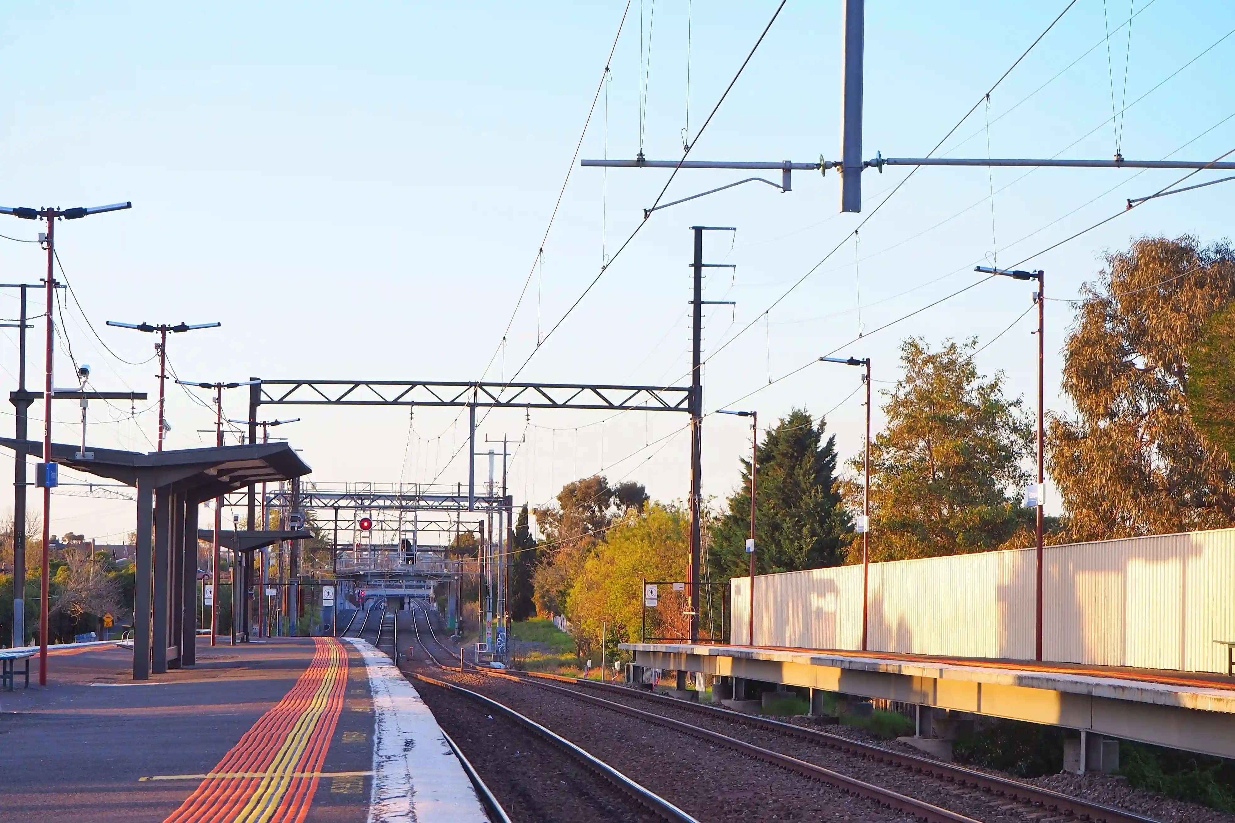 Electrical infrastructure at Bentleigh East train station showcasing commercial electrical systems with overhead power lines and lighting installations