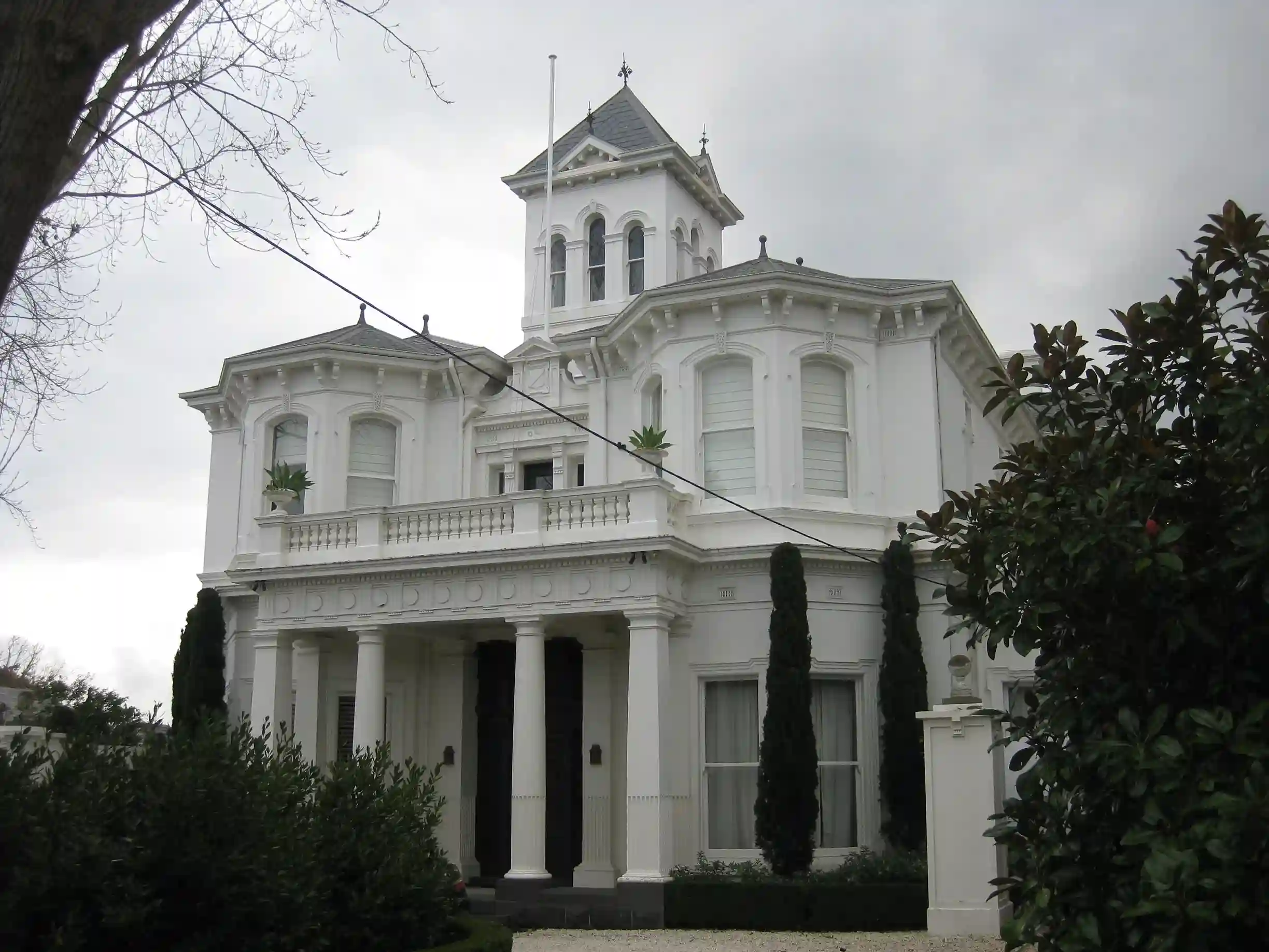 Historic white Victorian mansion with columns and tower in Toorak.