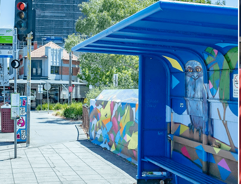 Bus shelter features a colorful owl mural and is part of a local public art project.