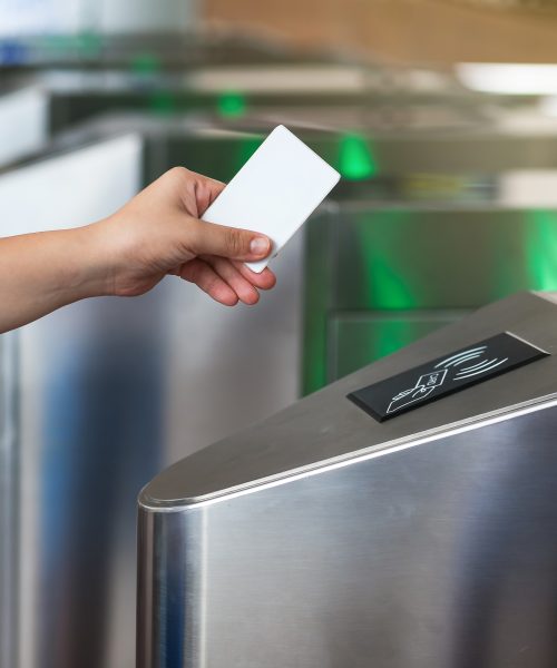 A person using a card to access a secured turnstile pedestrian access control system.