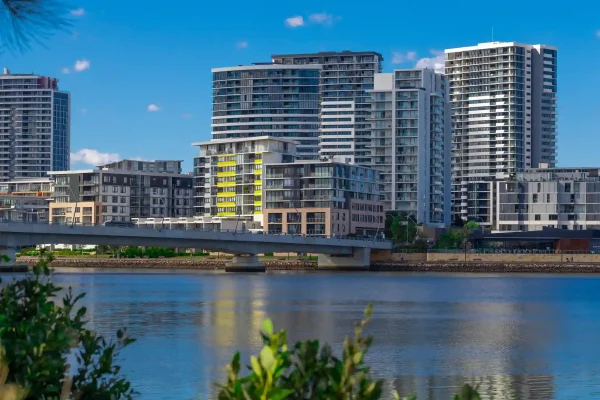 High-rise residential apartments near waterfront in Melbourne, with a bridge in the foreground.